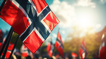 Norwegian flags waving energetically during national holiday celebration, filling blue sky with patriotic spirit while crowds gather joyfully in Oslo's streets