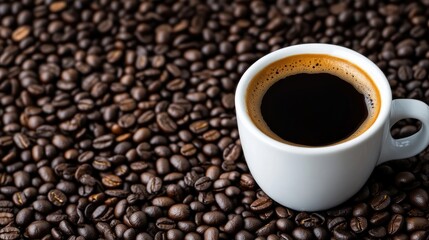 Fototapeta premium Espresso in a white cup surrounded by coffee beans