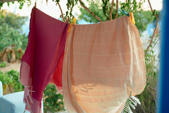 Colorful clothes hang on a line outdoors in a sunny garden setting. Mykonos, Greece