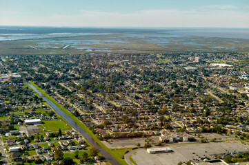 Aerial view of a coastal city with suburban neighborhoods and distant wetlands. New Orleans, Louisiana, USA