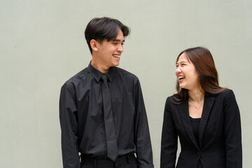 Portrait of young Asian couple wearing business uniform and laughing together