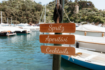 Wooden sign offering cocktails, aperitivi, and spritz in portofino, italy