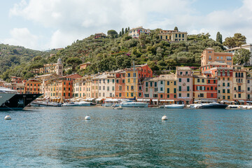 Portofino, italy: luxurious yachts docking near colorful italian riviera buildings on a sunny summer day