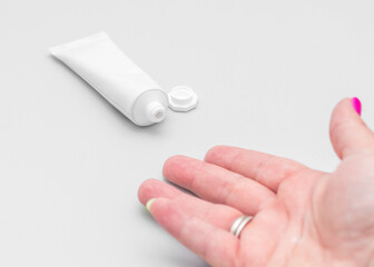Woman's hand reaching for a tube of cream