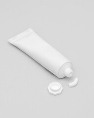 White tube of cream or ointment with cap on white background