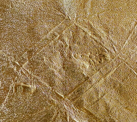 Gold paper texture seamless background. Uneven rough golden textured with different shadings and contour. Seamless background texture