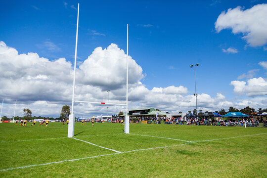 Goal posts of sports field with crowd of spectators watching the team play
