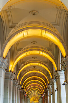 Looking down a row of lighted archways and pillars