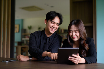 Young Asian couple sitting together in library