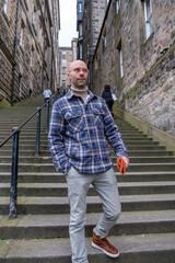 young traveler man explores medieval streets Edinburgh, ancient alleys, discovery archipelago...