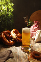 A mug with beer and traditional German bretzels in Bavarian rustic style