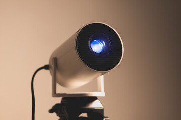Close up, lens of modern wi-fi video-projector with lighting blue light. Video or photo...