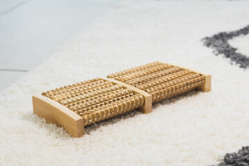 Wooden roller foot massager at home or office. Self-massage for relaxing legs.