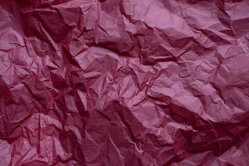 Texture of crumpled dark red wrapping paper