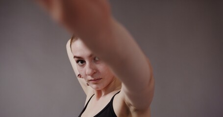 A beautiful girl with fair skin with freckles, with hair gathered in a ponytail, in a black top,...