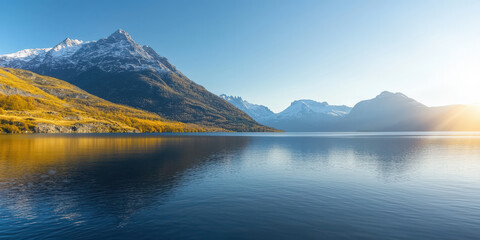 serene lake reflecting snow capped mountain under clear blue sky, surrounded by autumn foliage
