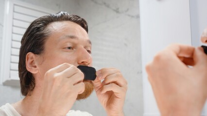 Man Pressing Black Tape on Mouth While Looking in Mirror from Front Angle in Bathroom, Anti Snoring and Nose Breathing Concept