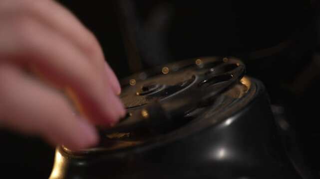 Person makes quick urgent call. Woman dialing numbers on an old vintage rotary style telephone. Retro phone with rotary dial. Fingers dialing a phone number. Vintage telephone old style, close up