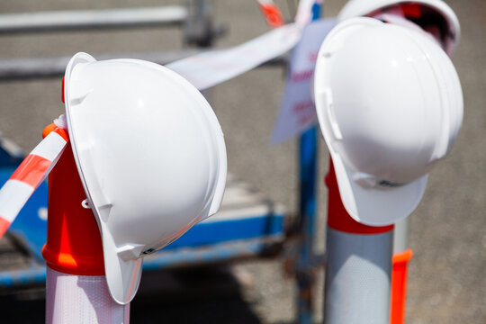 Two hard hats sitting on posts of taped off area