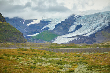 Scenic view of black volcanic mountains and Vatnajokull (Vatna glacier) in Iceland.