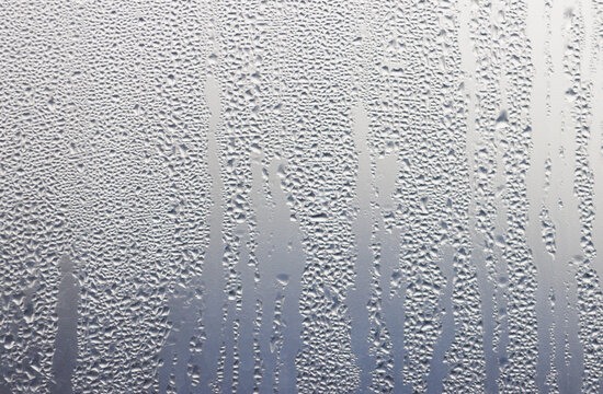 A window with water droplets on it, creating a blurry and hazy effect