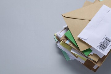 Post office. Stack of different paper envelopes on light grey background, top view. Space for text