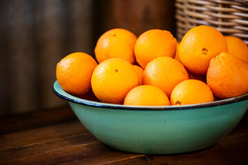 green enamel bowl of oranges