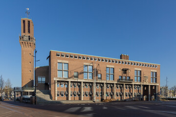 Hengelo city hall building with a tall clock tower under a clear blue sky. Iconic Dutch...
