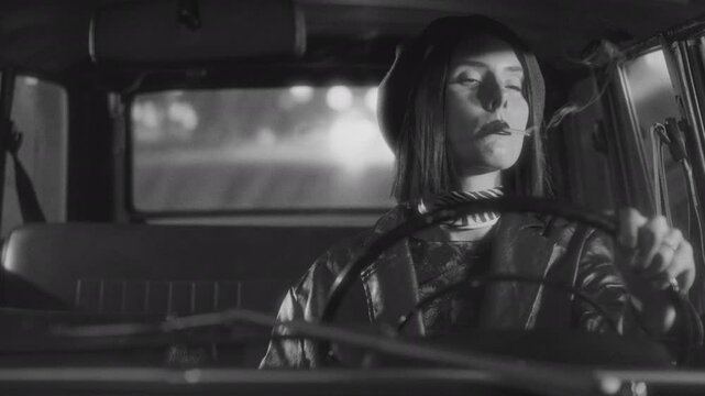 Beautiful woman wearing beret and leather jacket lighting cigarette and smoking while driving vintage car at night, captured in dramatic black and white film noir style