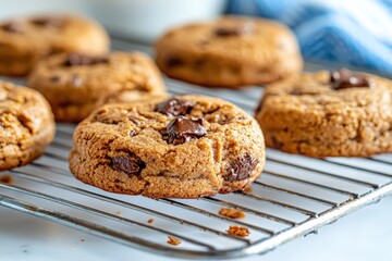 Freshly baked chocolate chip cookies cooling on a wire rack, tempting with their gooey chocolate and inviting aroma, perfect for dessert lovers and home baking enthusiasts.