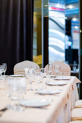 A beautifully arranged table awaits guests, adorned with sparkling glassware and white linens