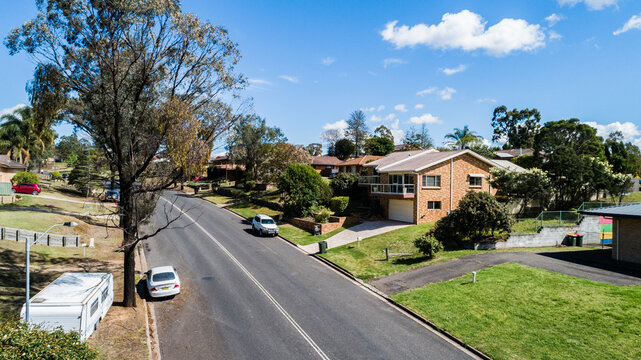 Double lines on road of suburban area with houses and parked cars