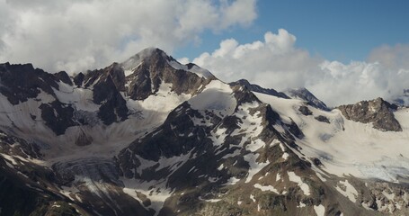 Obraz premium Russia, Elbrus. Rocky mountain peaks, rarely covered with snow, reach the clouds