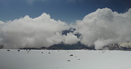 Russia, , Elbrus. Climbers descend from the top of the mountain using hiking sticks along a...