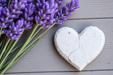 Fototapeta premium heart shaped stone next to a bunch of lavender flowers