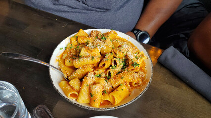 Creamy Rigatoni Pasta with Parmesan and Herbs in Rustic Bowl