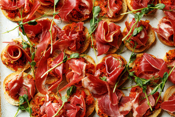 Delicious Italian-style crostini topped with thin slices of prosciutto and a savory tomato relish.