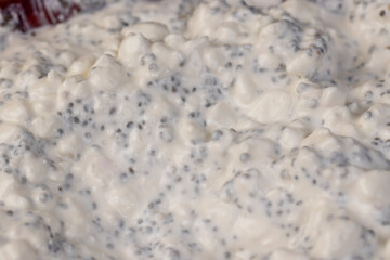 grainy cottage cheese with cream on the table during cooking with spices and chia seeds