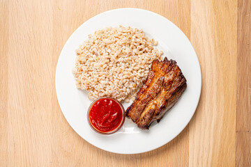 Savor a tender piece of grilled meat alongside fluffy rice and a bold sauce for a delightful meal