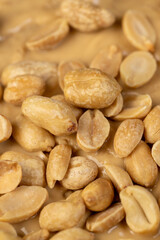 wheat bread with bran and soft peanut butter, peanut butter on a piece of bread and peanuts on the table