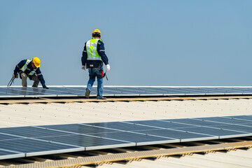 Two engineers install solar panels on a rooftop, wearing safety gear and helmets. The scene showcases renewable energy, green technology, and sustainable solutions under a clear blue sky.
