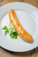 Grilled sausage on a white plate, garnished with fresh cilantro, is a culinary delight