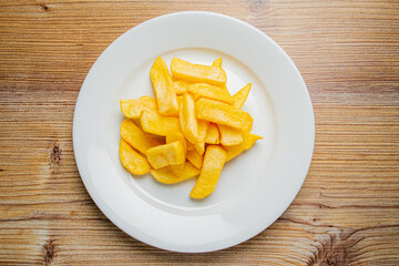 Golden fried potato slices arranged beautifully on a white plate invite indulgence and enjoyment