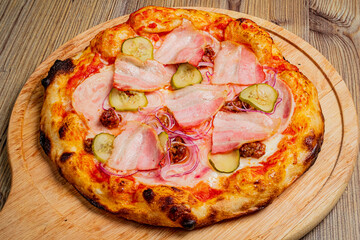 Freshly baked pizza featuring crispy bacon, tangy pickles, and sweet onions on a golden crust