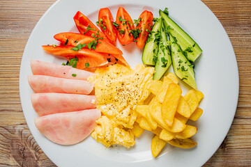 A colorful breakfast features scrambled eggs, veggies, and golden fries for morning delight