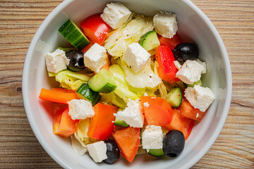 A colorful bowl of lettuce, tomatoes, cucumbers, olives, and feta promotes healthy eating