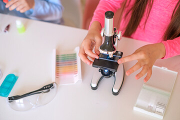 Close-up of a microscope and glass with sample cells for examination.