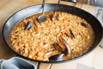 Traditional spanish seafood paella with mussels, shrimp, and rice in pan