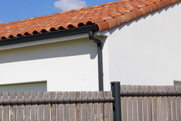 Gouttière aluminium gris anthracite sur la façade de la maison, descentes rectangulaires et lambris de sous-face en pvc blanc