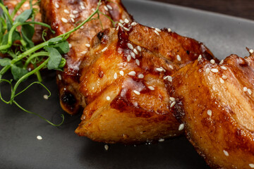 Stewed meat with sesame on a black plate, Japanese cuisine